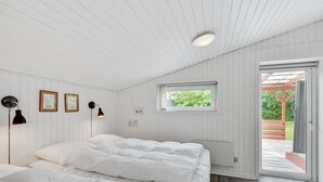 A bedroom with a large bed, a window, and a door leading to an outdoor area. - "Anline" - 900m to the fjord by Interhome (Tarm)