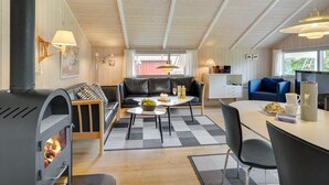 A cozy cabin interior with a fireplace, a dining area, and a living space with a sofa and a TV. - "Danna" - 850m to the fjord by Interhome (Hemmet)