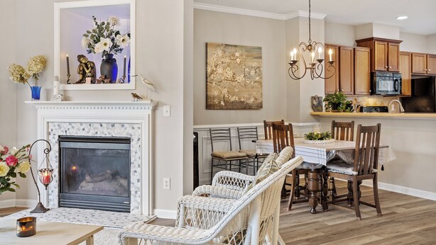 A modern kitchen with wooden cabinets, a dining area with wicker chairs, and a fireplace with a mantel. - Amazing Location Near Cary/Morrisville/Apex Downtown, Close to RDU/RTP/ Shopping (Cary)
