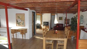 A dining area with a wooden table and chairs, a television in the background, and a red-framed doorway leading to another room. - "Beatha" - 25km to the fjord by Interhome (Sønder Felding)