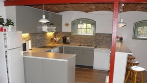 A modern kitchen with a central island, built-in appliances, and wooden stools. - "Beatha" - 25km to the fjord by Interhome (Sønder Felding)