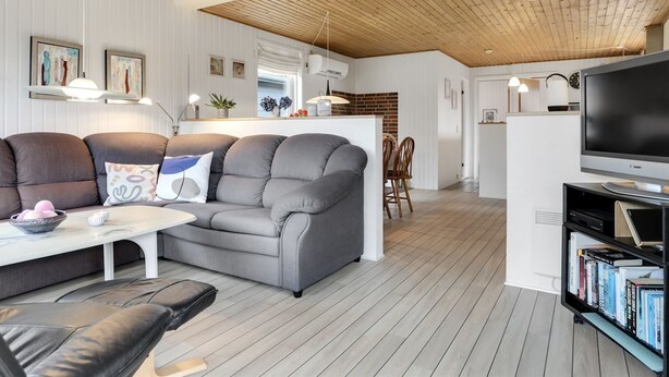 A modern living room with a grey sofa, a coffee table, and a bookshelf.