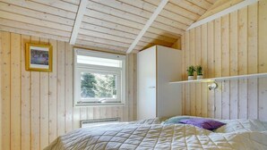 A bedroom with a bed, a window, a shelf with plants, and a framed picture on the wall. - "Wegher" - 650m from the sea by Interhome (Væggerløse)