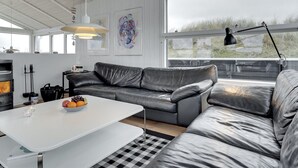 A modern living room with a grey leather sofa, a white coffee table, and a fireplace. - "Swerting" - 230m from the sea by Interhome (Saltum)
