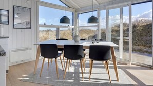 A modern kitchen with a large dining table, black chairs, and pendant lights. - "Swerting" - 230m from the sea by Interhome (Saltum)