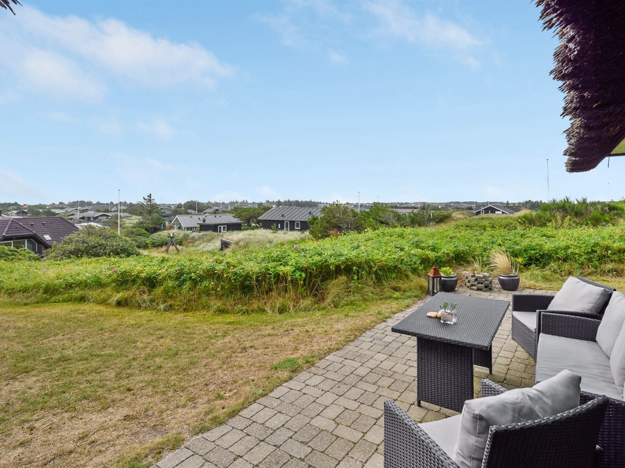 A patio area with outdoor furniture and a view of houses in the background.