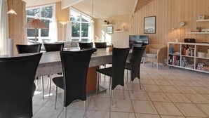 Eine moderne Küche mit Essbereich, Holzwänden und großen Fenstern.
