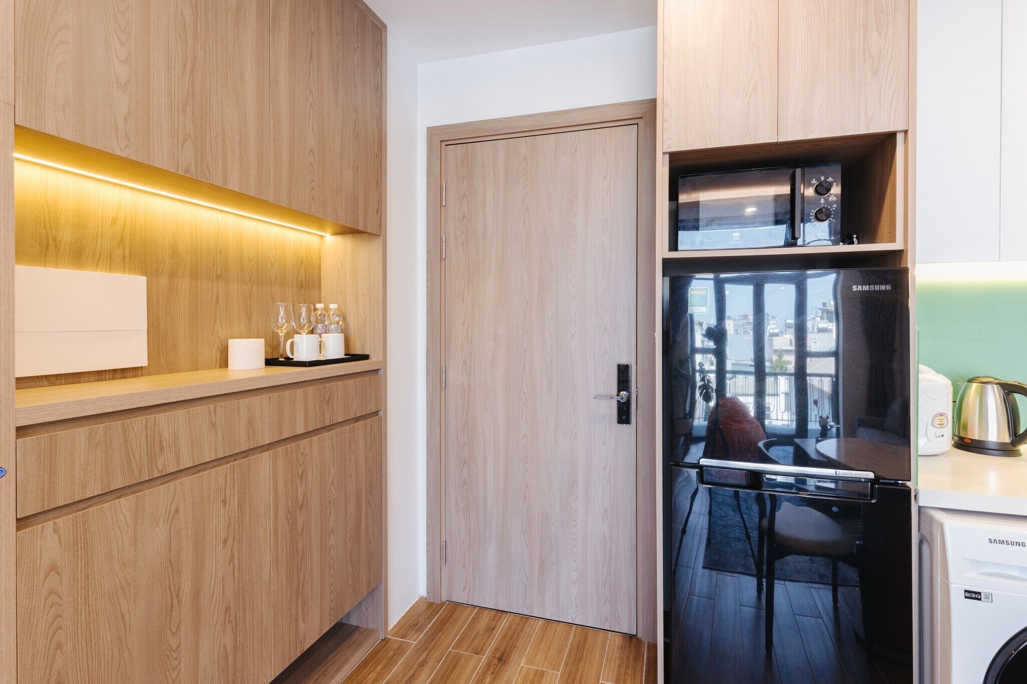 A modern kitchen with wooden cabinetry, a built-in microwave, and a Samsung refrigerator.