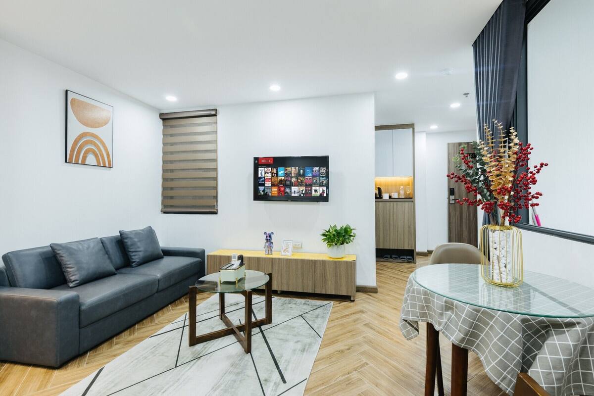 Un salon moderne avec un canapé, une table basse et un téléviseur fixé au mur.