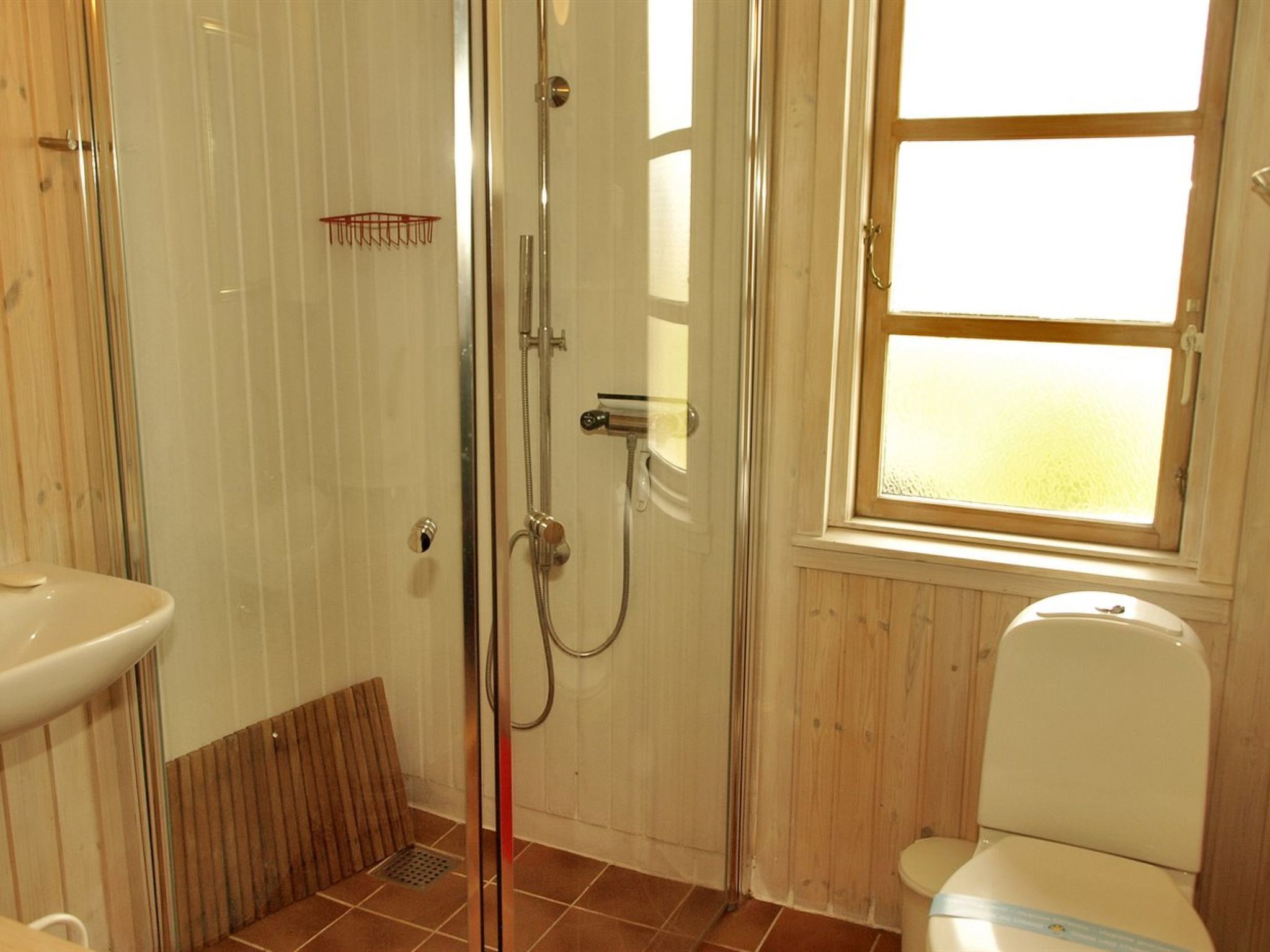 A bathroom with a shower, toilet, and sink.