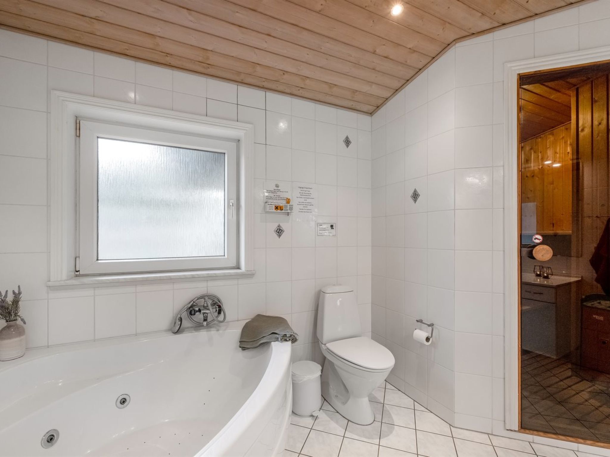 Une salle de bain avec une baignoire, des toilettes et une fenêtre.