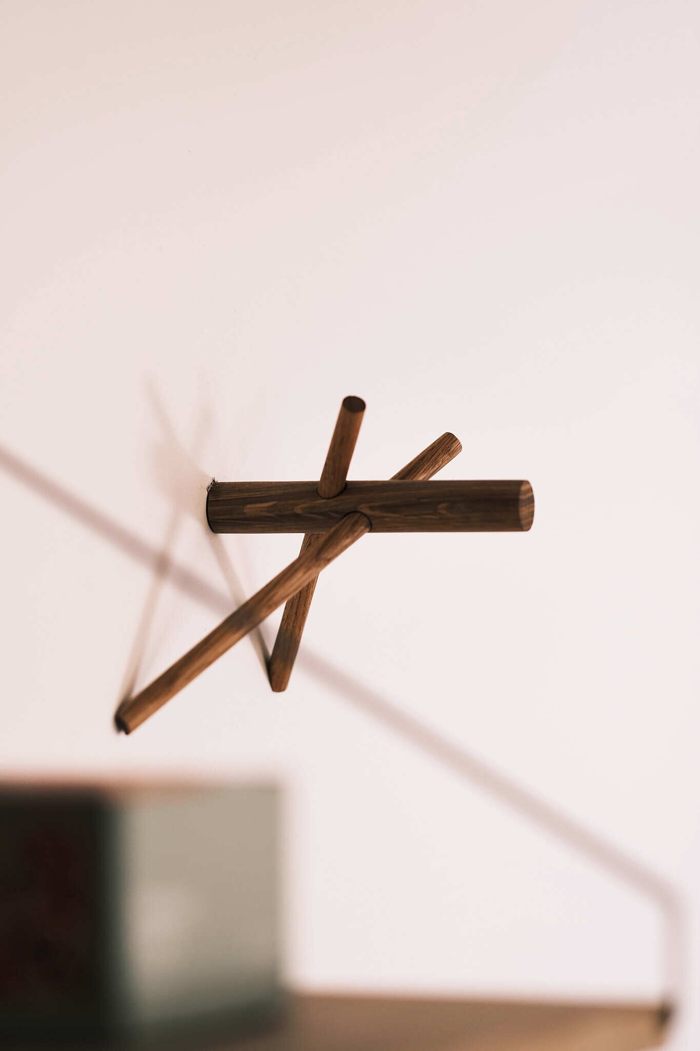 A wooden structure with intersecting beams against a plain background.