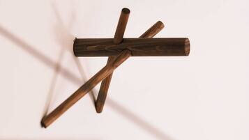 A wooden structure with intersecting beams against a plain background.