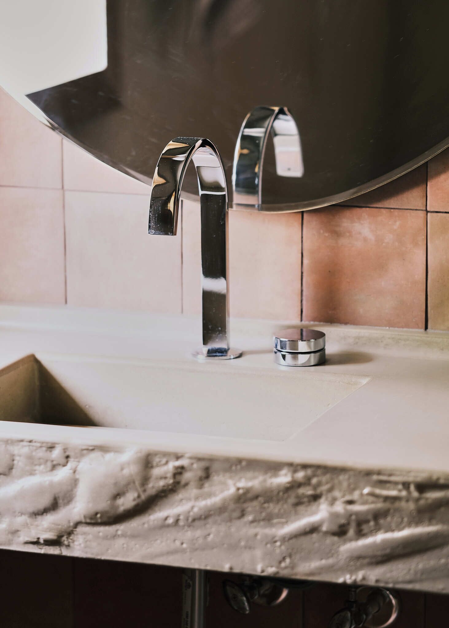 A bathroom sink with a chrome faucet and a mirror above it.