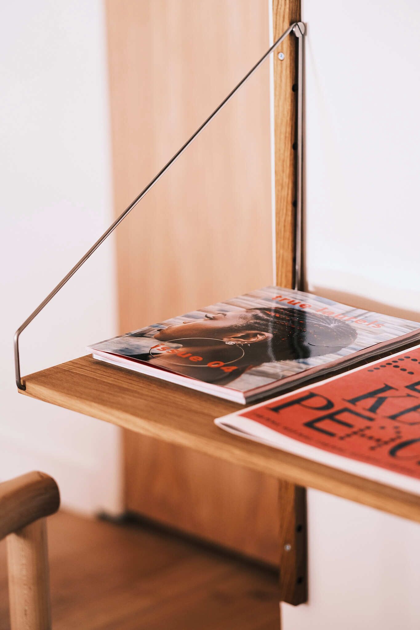 Una estantería de madera con revistas y un libro.
