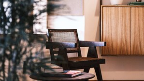 A cozy seating area with a chair and a small table, a wooden cabinet with shelves, and a framed artwork on the wall. - guesthouse by good neighbor (Baltimore)