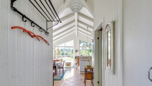 A narrow hallway with a tiled floor, a radiator, and a door leading to a dining area with a table and chairs. - "Nela" - 300m from the sea by Interhome (Grenaa)