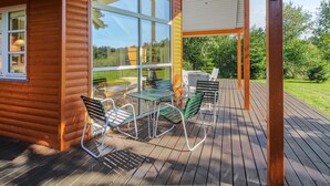 A wooden cabin with a deck, large windows, and outdoor furniture. - "Nela" - 300m from the sea by Interhome (Grenaa)