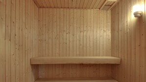 A wooden sauna with benches and a light fixture on the wall. - "Soufiane" - 100m from the sea by Interhome (Vejers Strand)
