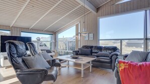 En rummelig stue med højt til loftet, store vinduer og et moderne design.