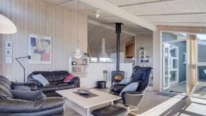 En moderne stue med lædermøbler, et hvidt sofabord og en pejs.