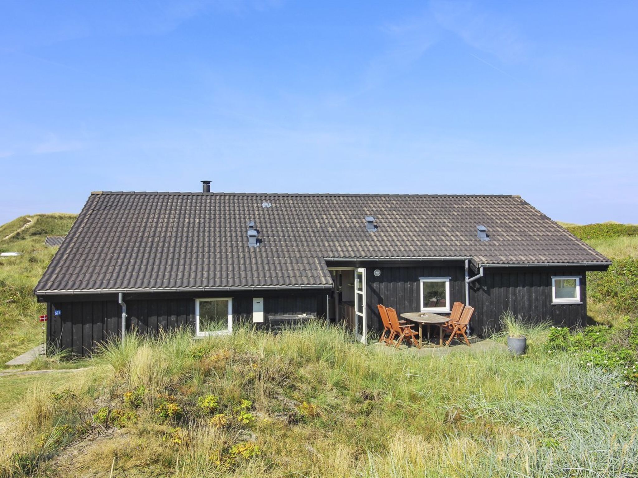 A single-story house with a dark roof and a small porch area.