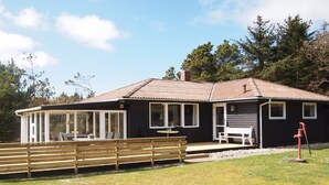 A cabin with a deck, a covered patio, and a small outdoor seating area.