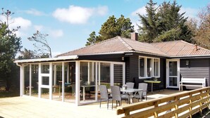 A modern house with a covered patio, large windows, and a deck.