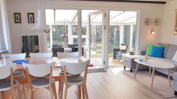 A modern living room with a glass door leading to an outdoor patio.