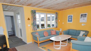 Ein gemütliches Wohnzimmer mit einer Sofagarnitur, einem Couchtisch und einem Kamin.