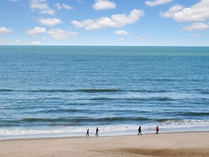Uma praia com céu claro e mar calmo.