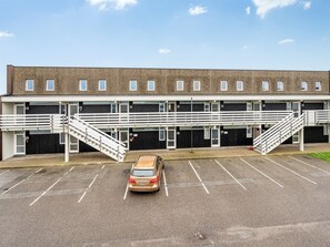 Un parking à plusieurs étages, avec une voiture garée au premier plan.