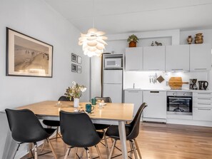Een moderne keuken met witte kasten, een magnetron en een inbouwoven.
