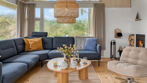 A modern living room with a sectional sofa, a round coffee table, and a fireplace.