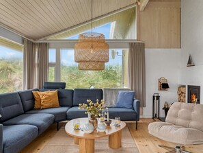 A modern living room with a sectional sofa, a round coffee table, and a fireplace.