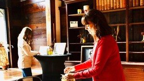 Habitació amb terres de fusta, taula rodona amb estovat blanc, una cadira i una estanteria plena de llibres i un senyal de Wi-Fi.