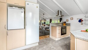 Une cuisine moderne dotée d’un réfrigérateur, d’un four et d’un plan de travail en granit intégrés.