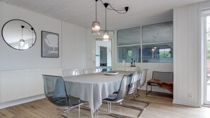 A modern dining area with a round table, clear chairs, pendant lighting, and a large window. - "Joona" - 12km from the sea by Interhome (Oksbøl)