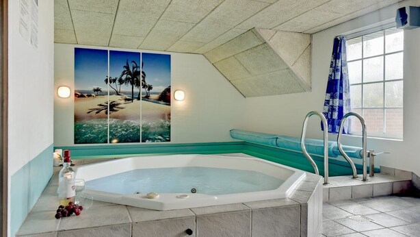 A spa room with a hot tub, a view of the beach, and a window with blue curtains. - "Joona" - 12km from the sea by Interhome (Oksbøl)