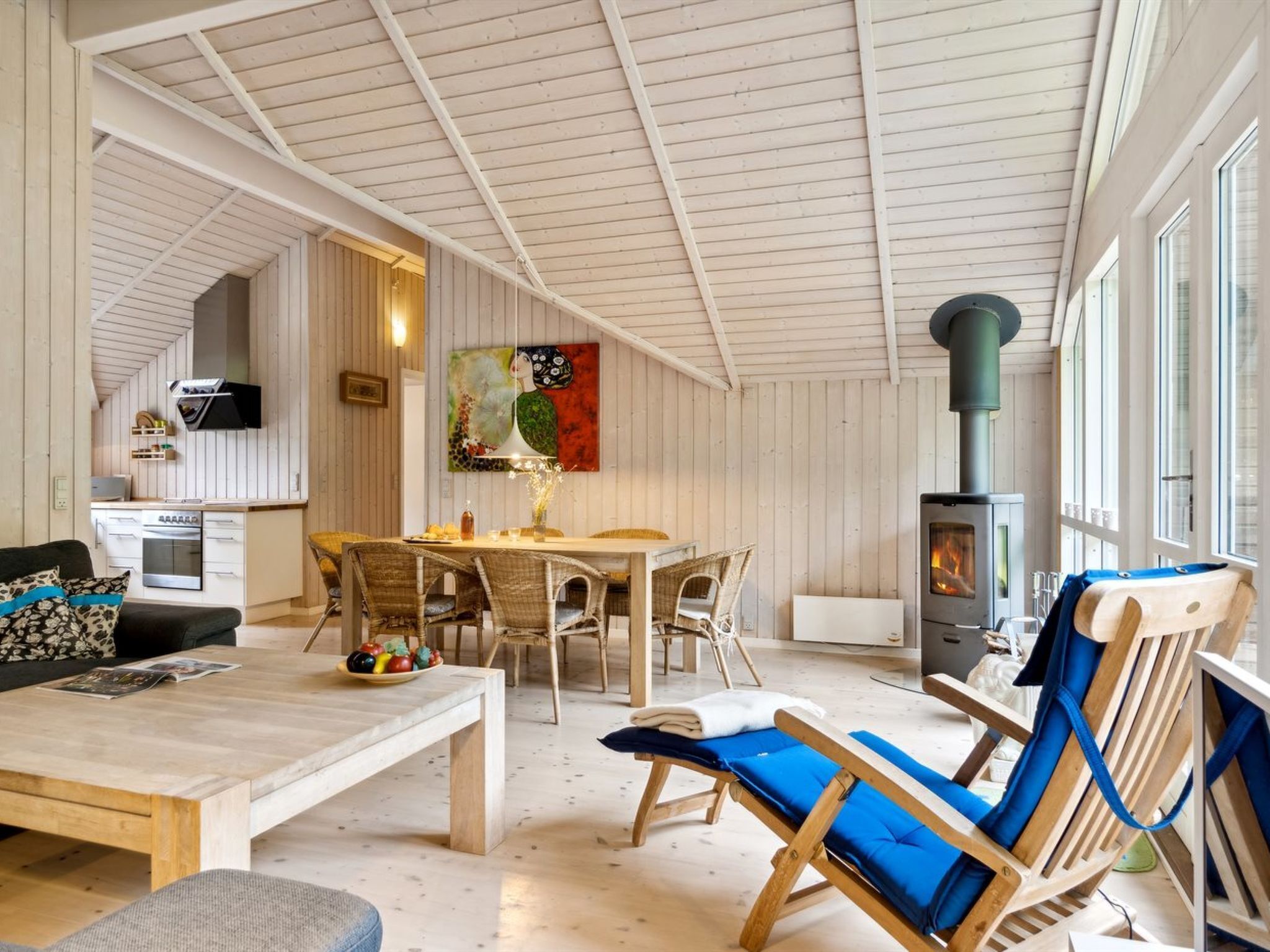 Un intérieur chaleureux comprenant un coin repas, un canapé, un fauteuil et un poêle à bois.