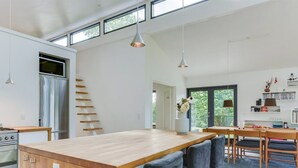Een moderne keuken met een houten eiland, roestvrijstalen apparatuur en een inbouwoven.