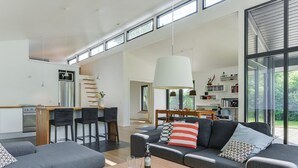 Een moderne woonruimte met keuken, eethoek en zithoek.