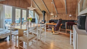 A cozy cabin interior with a dining area, sofa, and fireplace. - "Carlotta" - 12km from the sea by Interhome (Oksbøl)