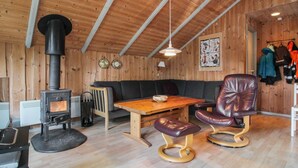 A cozy cabin interior with a wood stove, leather seating, and a dining table. - "Carlotta" - 12km from the sea by Interhome (Oksbøl)