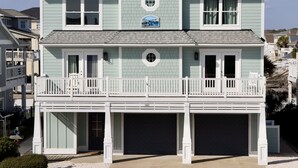 A two-story house with a balcony, a garage, and a sign on the front.