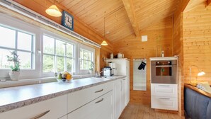 Eine moderne Küche mit weißen Schränken, einer Granit Arbeitsplatte und Holzboden.