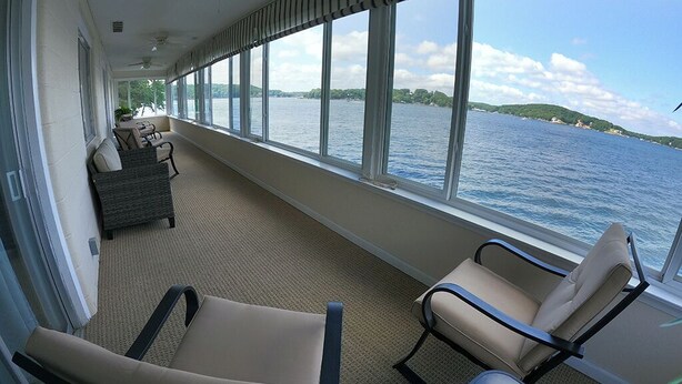 A balcony with two chairs and a sofa, overlooking a body of water. - Lakefront living on the 4MM - Best views on the Lake! (Rocky Mount)