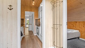 A compact room with a wooden floor, a bed, a kitchenette, and a coat rack. - "Dorthe" - 300m to the fjord by Interhome (Tarm)