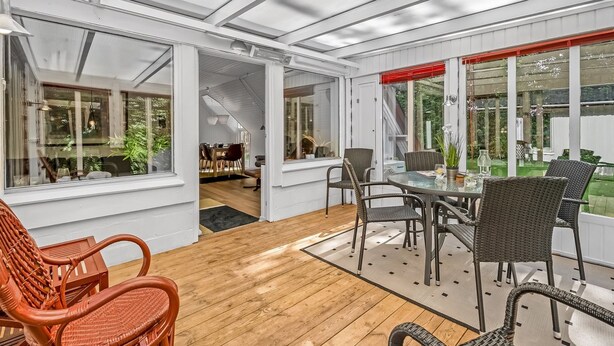 A spacious patio area with a dining table and chairs, large windows, and a view of the garden. - "Dorthe" - 300m to the fjord by Interhome (Tarm)
