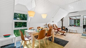A modern dining area with a wooden table, leather chairs, and a large window. - "Dorthe" - 300m to the fjord by Interhome (Tarm)